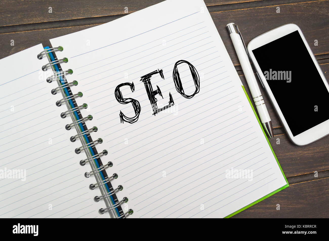 Seo (search engine optimization) in un notebook con uno smart phone sul tavolo, la concezione di business. Foto Stock