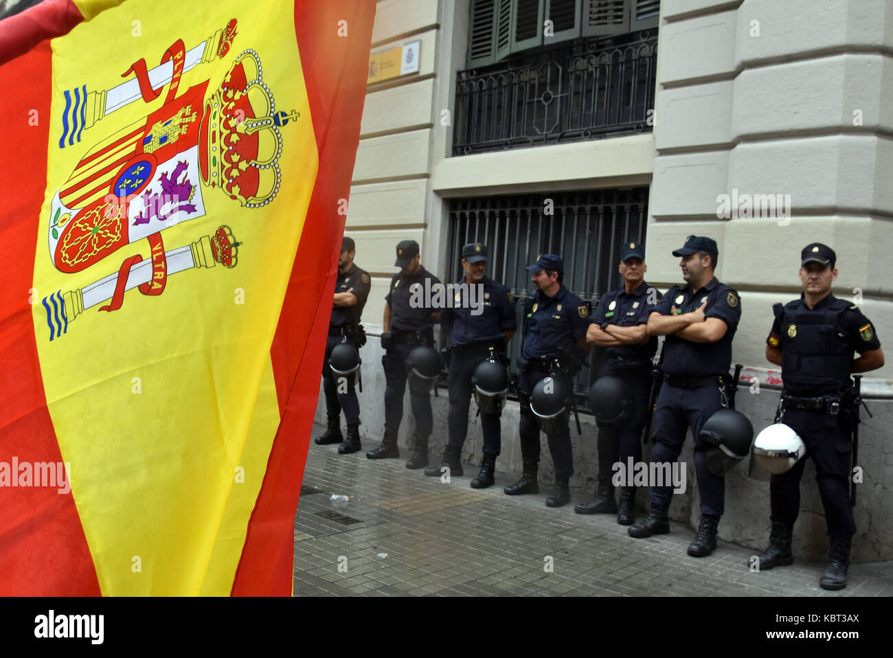 Anti referendum nazionalista spagnolo mostra una bandiera nazionale di fronte alla polizia. Circa 5.500 secondo la guardia urbana e 15.000 secondo il governo centrale ha aderito il sabato pomeriggio dal centro di Barcellona, in Plaza Urquinaona, in favore dell unità della Spagna e contro lo svolgimento del referendum. Foto Stock