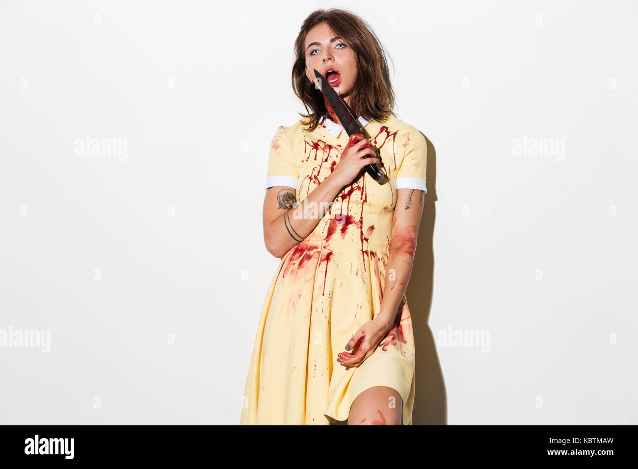 Spurgo scary zombie donna tenendo un coltello per il suo viso isolate su sfondo bianco Foto Stock