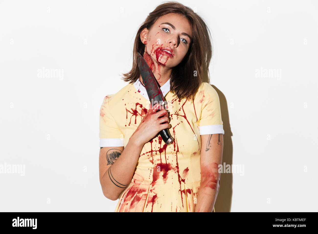 Ritratto di una donna in orrore zombie compongono tenendo un coltello isolate su sfondo bianco Foto Stock