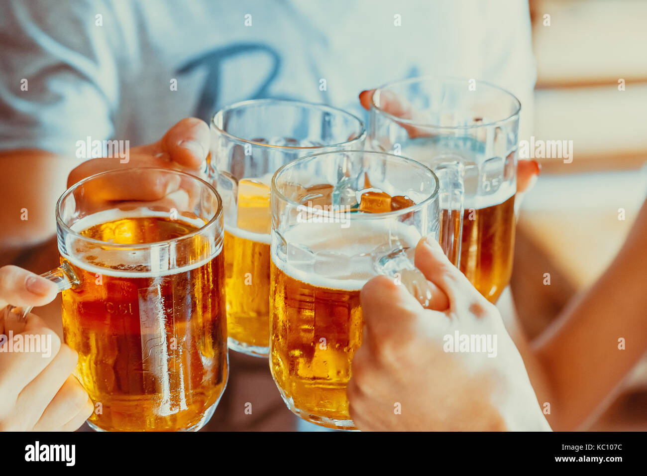 Felice gli amici a bere birra e bicchieri tintinnanti al pub, di svago, di amicizia e di celebrazione del concetto. bellissimo sfondo della Oktoberfest. un gruppo Foto Stock