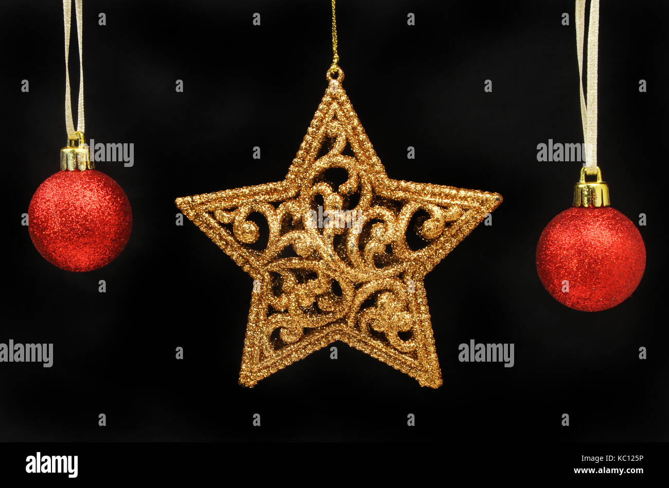 Oro glitter stella di Natale e baubles rosso isolato nei confronti del nero Foto Stock