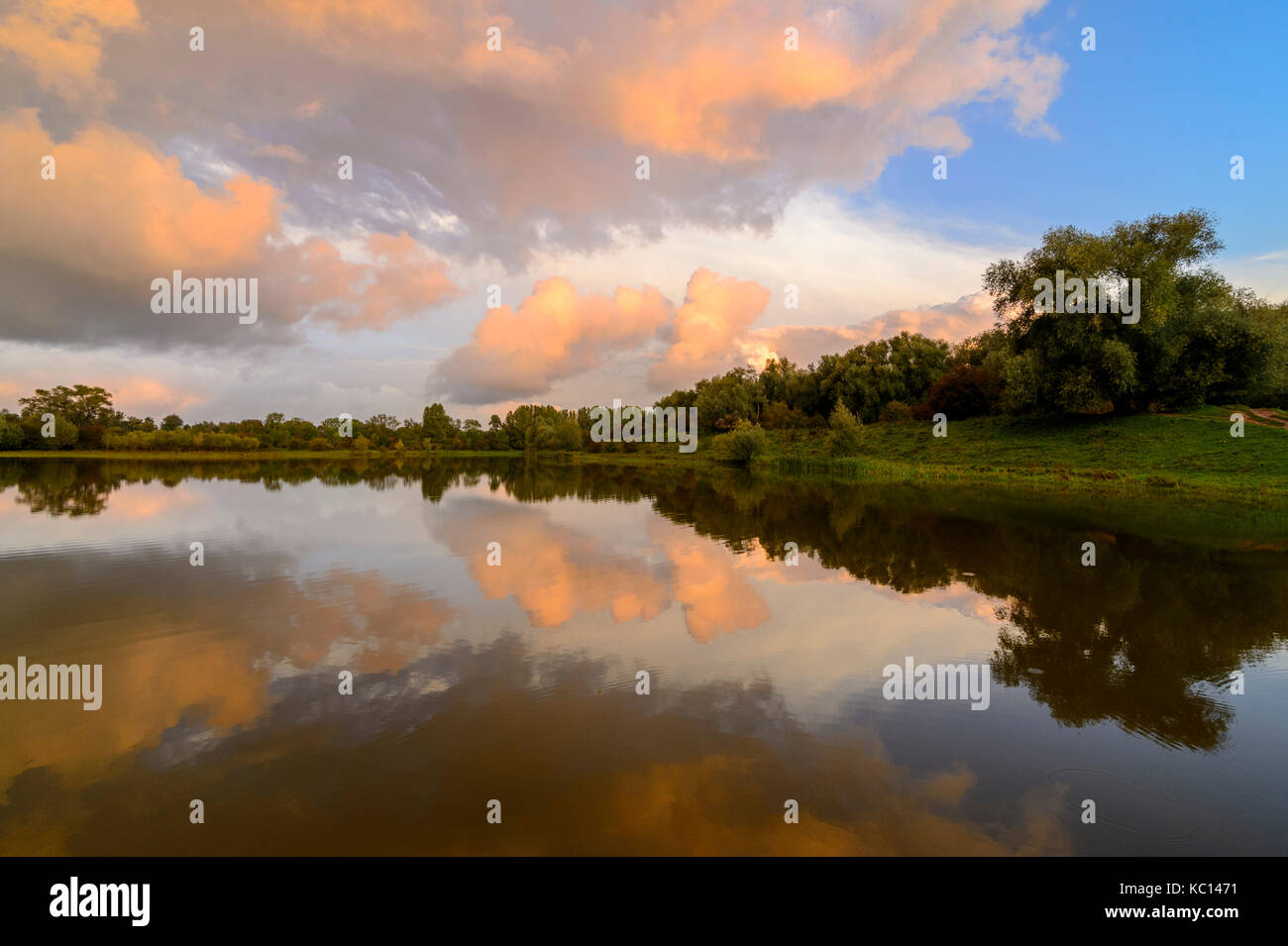 Sera nuvole riflettono in un tranquillo lago Foto Stock