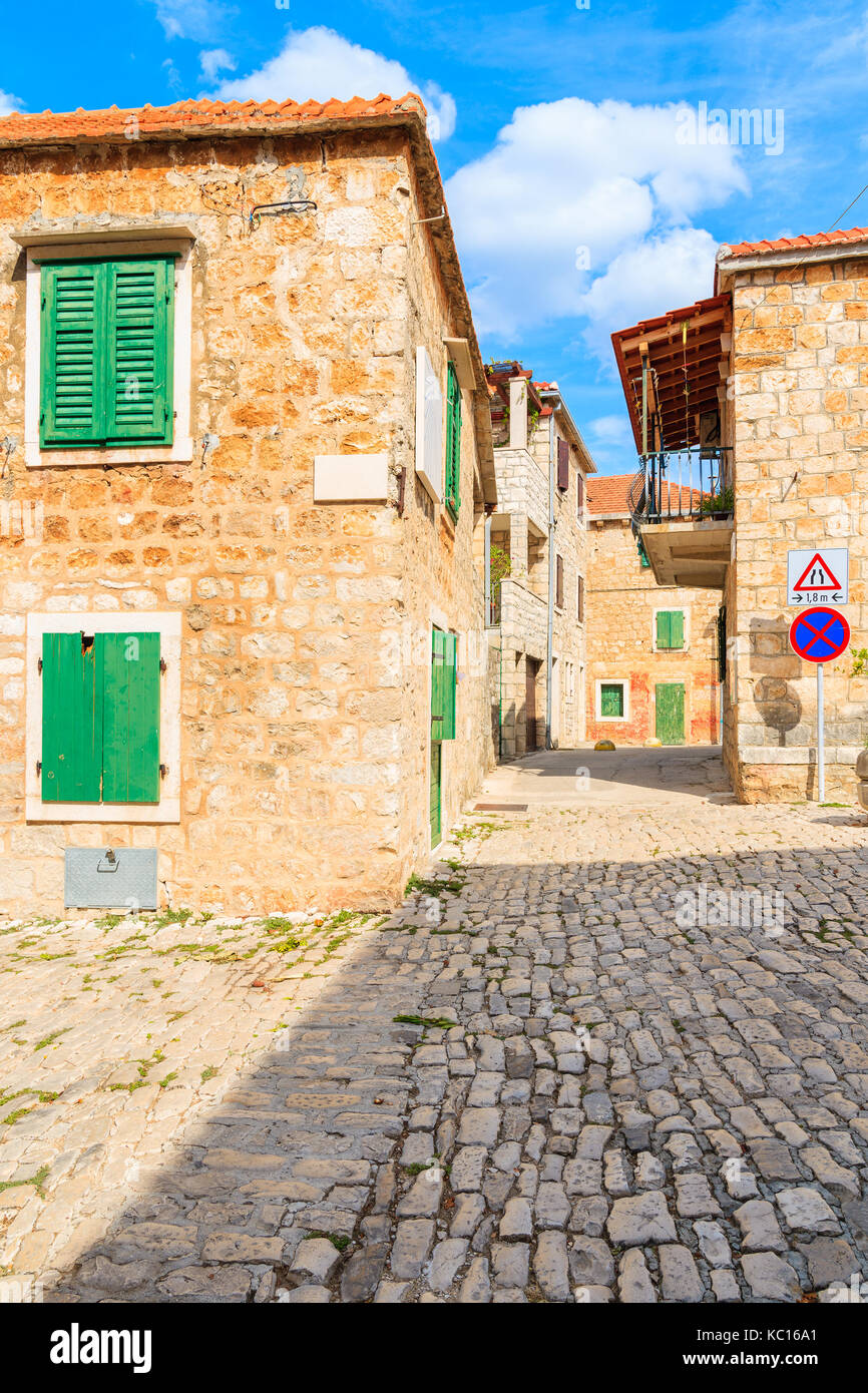 Street con le tipiche case in pietra in Postira città vecchia, isola di Brac, Croazia Foto Stock