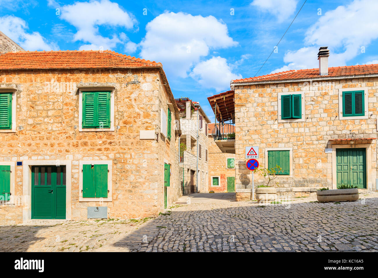 Street con le tipiche case in pietra in Postira città vecchia, isola di Brac, Croazia Foto Stock