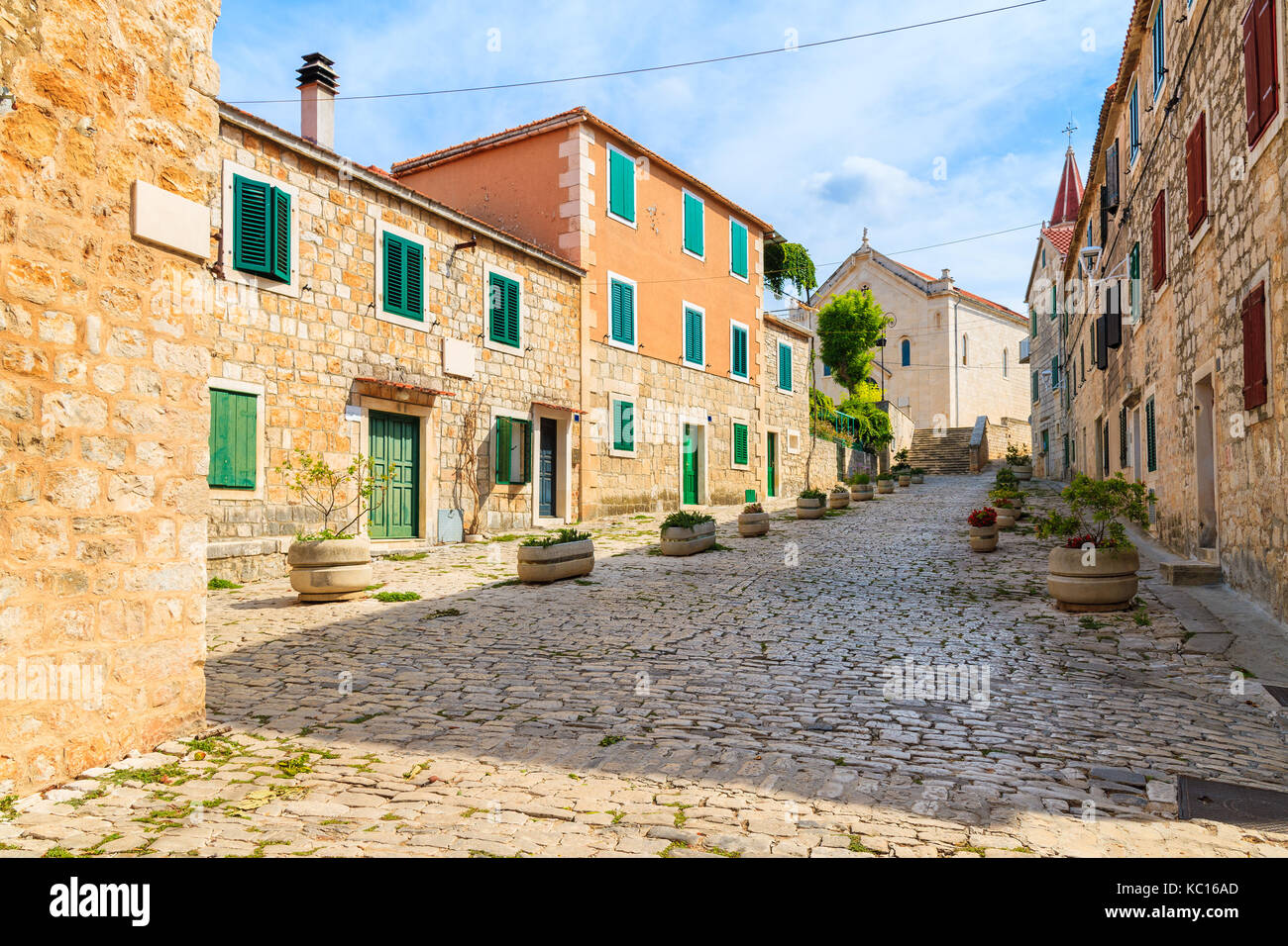 Street con le tipiche case in pietra in Postira città vecchia, isola di Brac, Croazia Foto Stock