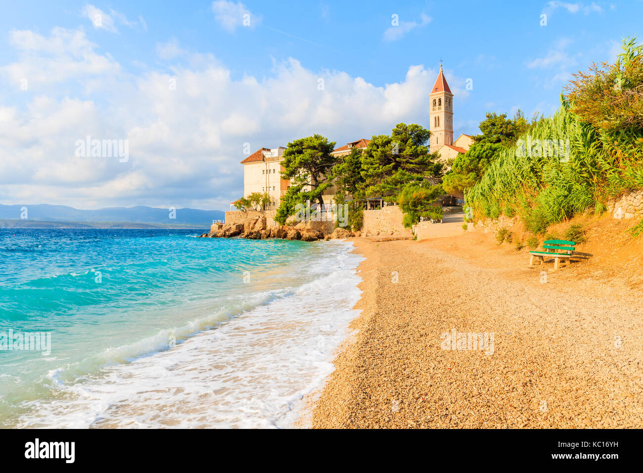 Onde sulla spiaggia con il famoso monastero domenicano nella città di Bol, isola di Brac, Croazia Foto Stock