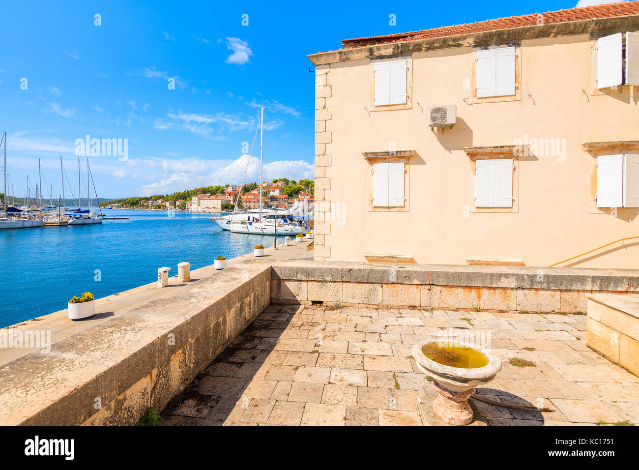 Vista del porto di Milna dal cortile della chiesa con gli edifici storici, isola di Brac, Croazia Foto Stock