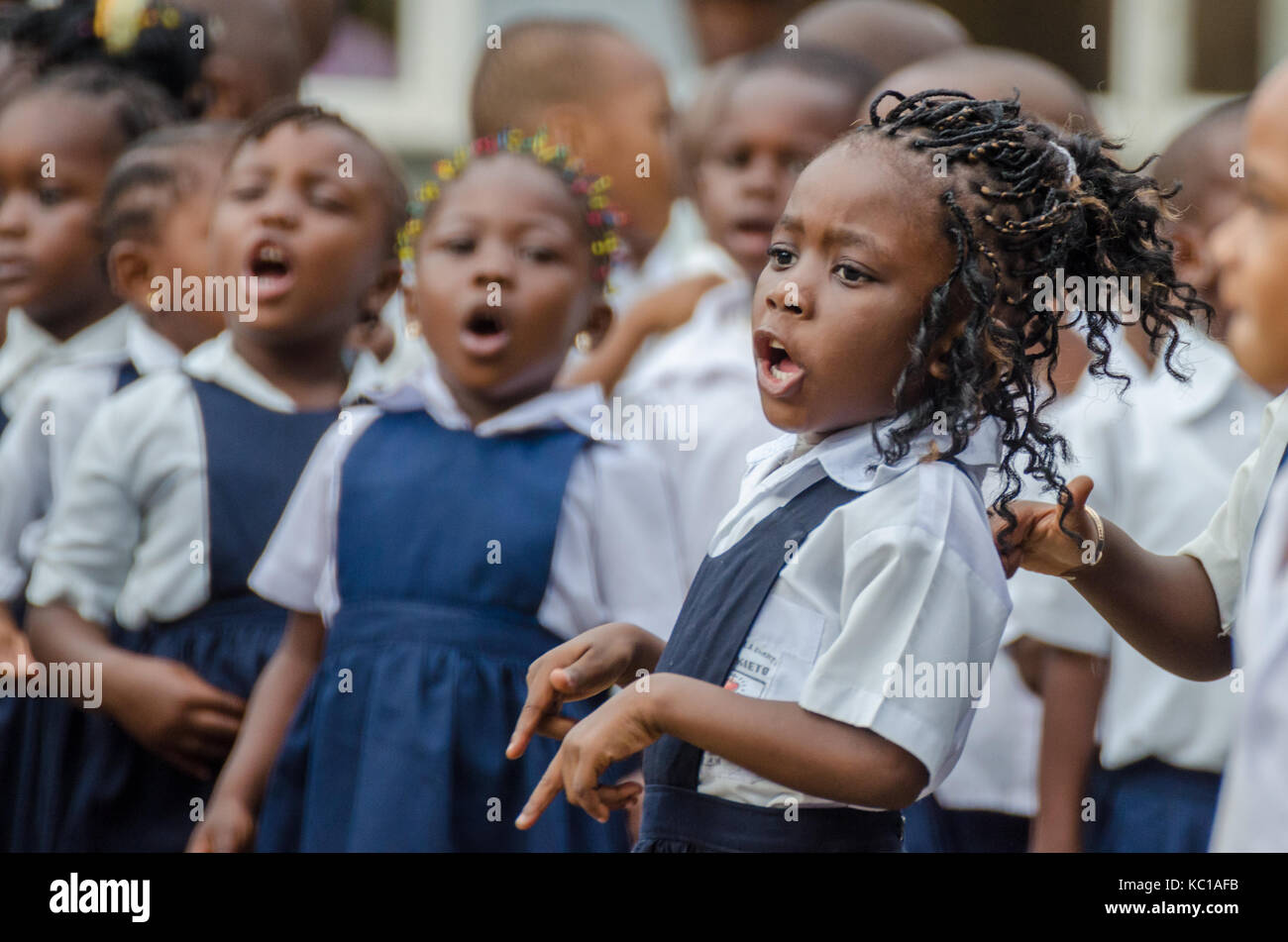 Giovani scuola africana ragazza con splendidamente decorate capelli di cantare e ballare a pre-school di Matadi, Congo, Africa Foto Stock