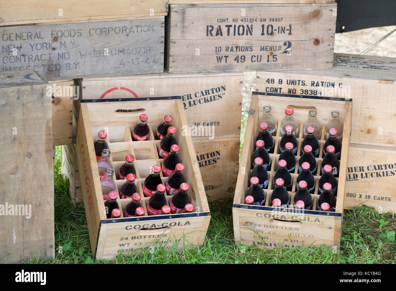 I recipienti di legno con coka cola bottiglie e l'esercito di razioni alimentari Foto Stock
