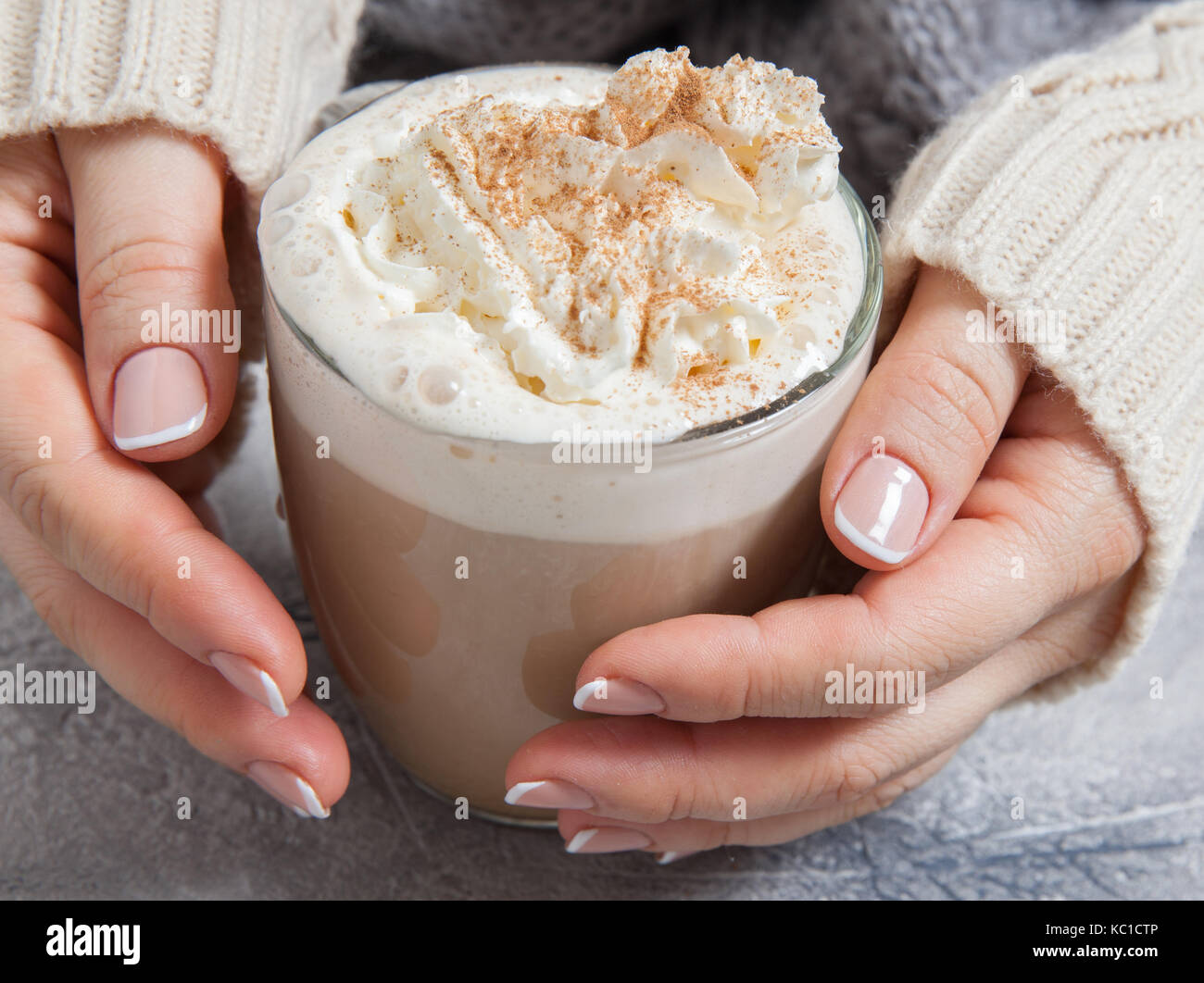 Donna mani con caffè latte su un tavolo Foto Stock