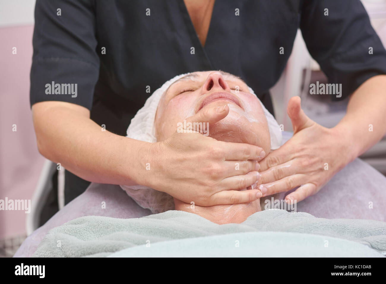 Massaggio linfodrenante viso, donna adulta. Foto Stock