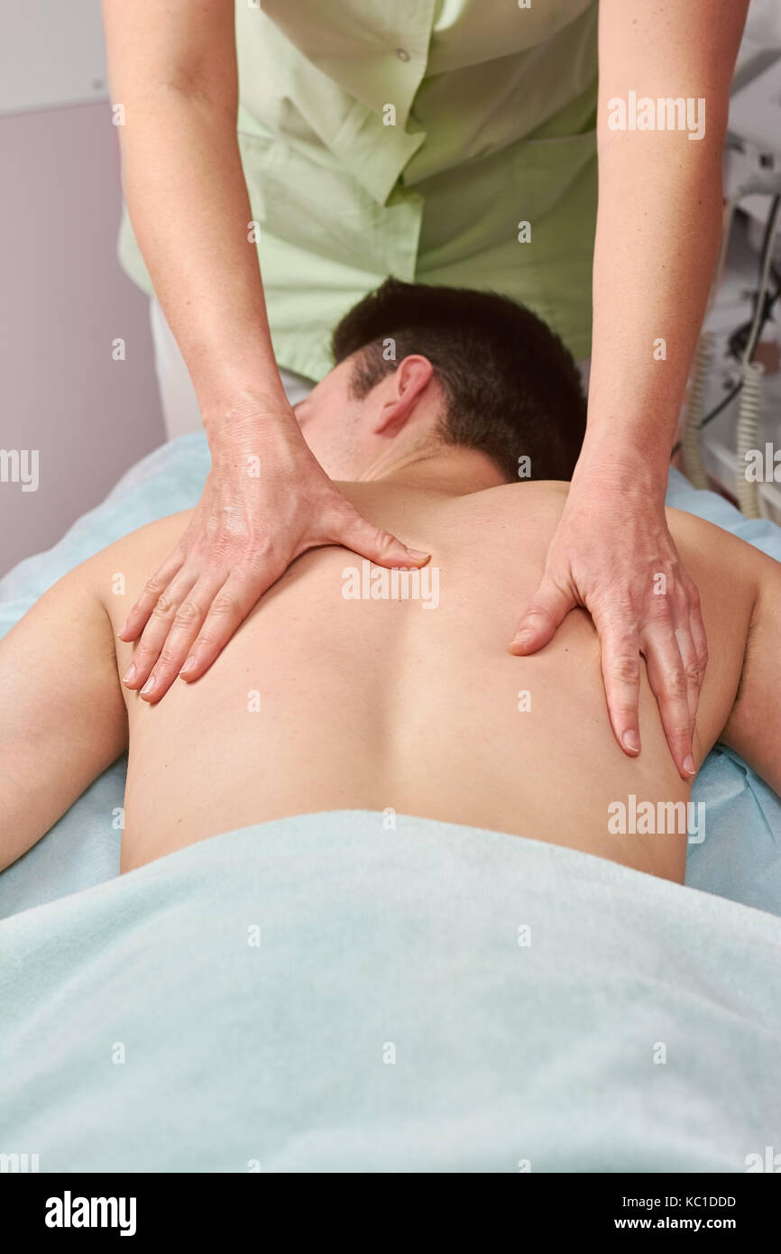 Mani femminili maschio massaggio schiena. Foto Stock