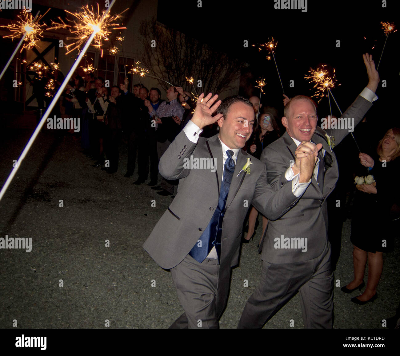 La gioia di nozze. matrimonio gay uscire attraverso il tunnel sparkler Foto Stock