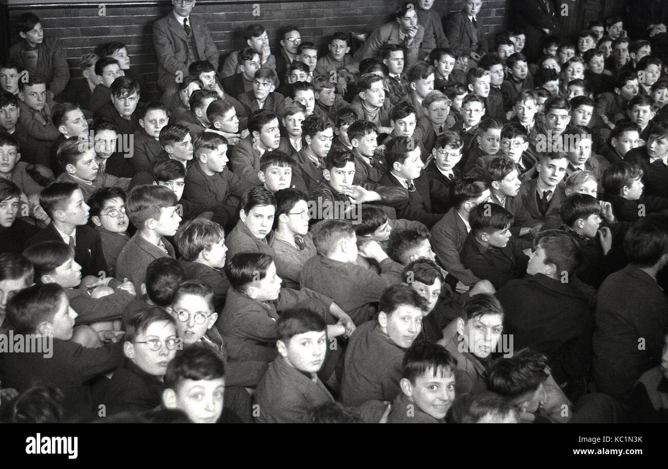 1948, foto storiche da post-ww2 Gran Bretagna, un folto gruppo di scuola di inglese ragazzi sedersi insieme in una sala della scuola in attesa di raccogliere un pacco alimentare dal Comitato della Australian Express pacchi regalo regime. Foto Stock