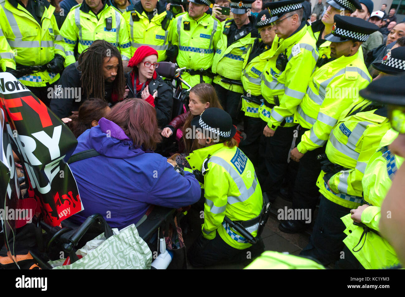 Manchester, Regno Unito. 1 Ott 2017. Gli attivisti disabili bloccare le tramvie come attivisti kettled sono in Piazza San Pietro a Manchester. Ant-Fracking attivisti e dusabled anti Tory attivisti soddisfare pesanti di sicurezza della polizia in piazza san Pietro nei pressi del centro conferenze. Pro-pace, anti-austerità, alle manifestazioni contro la guerra, comprese manifestazioni, incontri pubblici, commedia, musica e cultura, hanno luogo durante i quattro giorni del congresso del Partito Conservatore di Manchester, UK. 1° - 4° OTT 2017. Il festival di protesta è stata organizzata dall'assemblea del popolo. Credito: Graham M. Lawrence/Alamy Live News Foto Stock