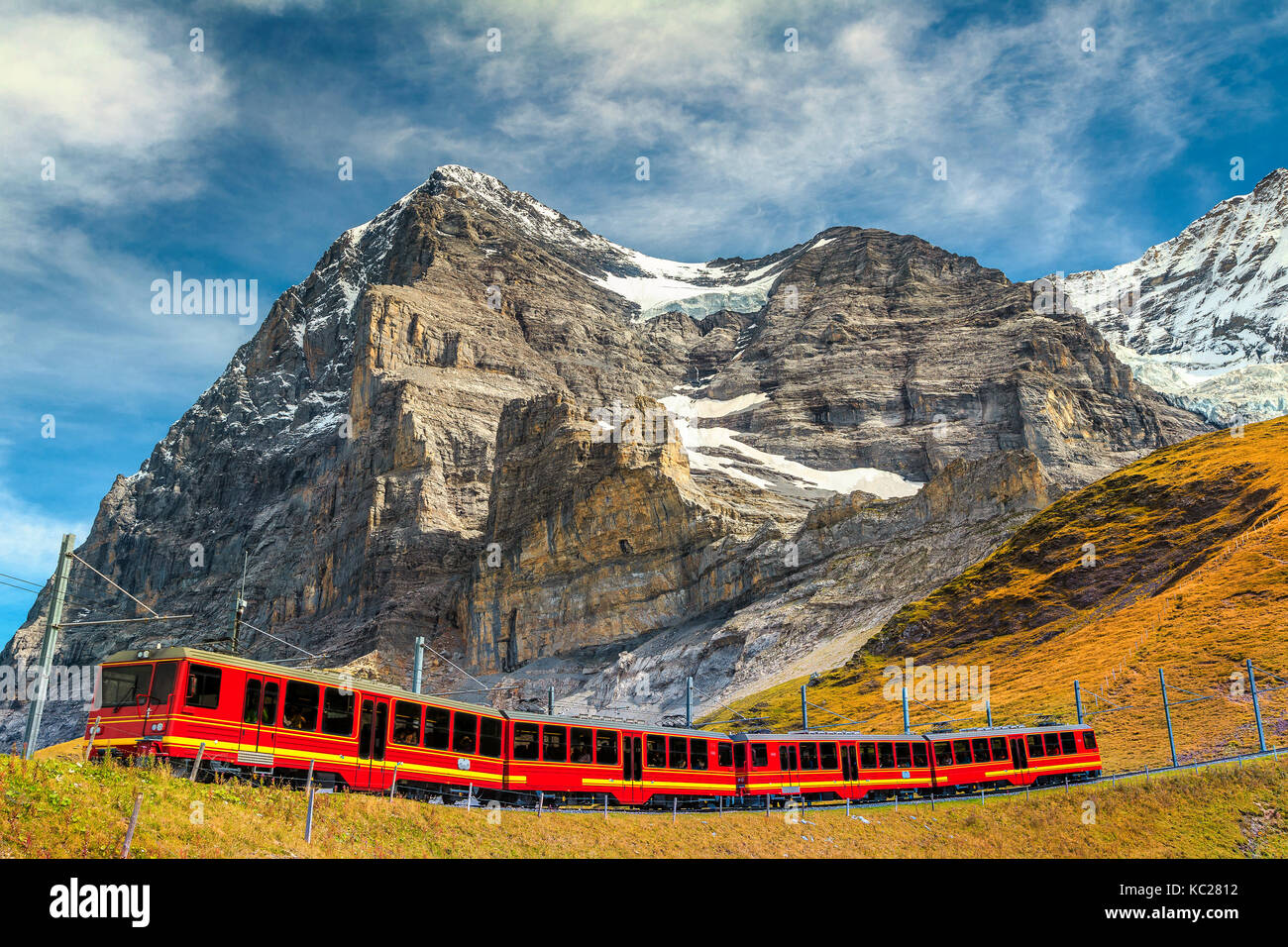 Il famoso esprimere rosso elettrico treno turistico che scendono dalla stazione Jungfraujoch(top d'Europa) in Kleine Scheidegg stazione turistica, oberla bernese Foto Stock