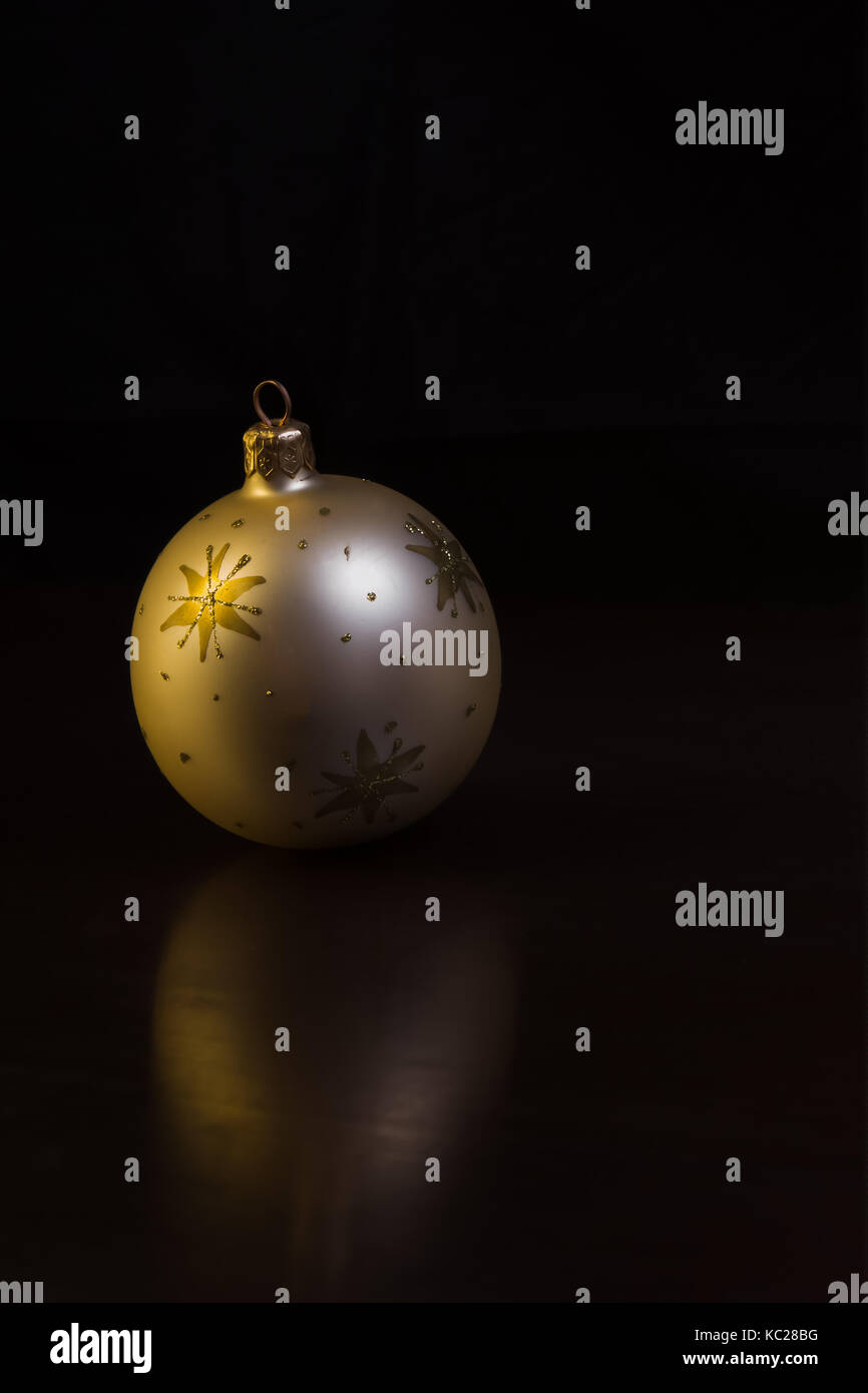 Di colore oro ornamento di Natale con reflextions su sfondo scuro Foto Stock