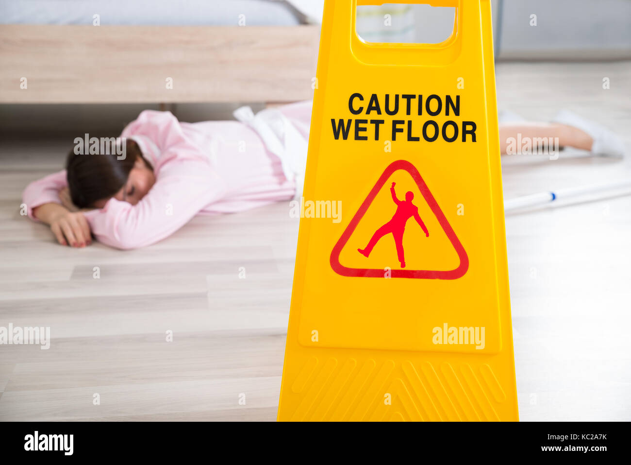 Close-up di un pavimento bagnato con segno svenuti governante sdraiato sul pavimento Foto Stock