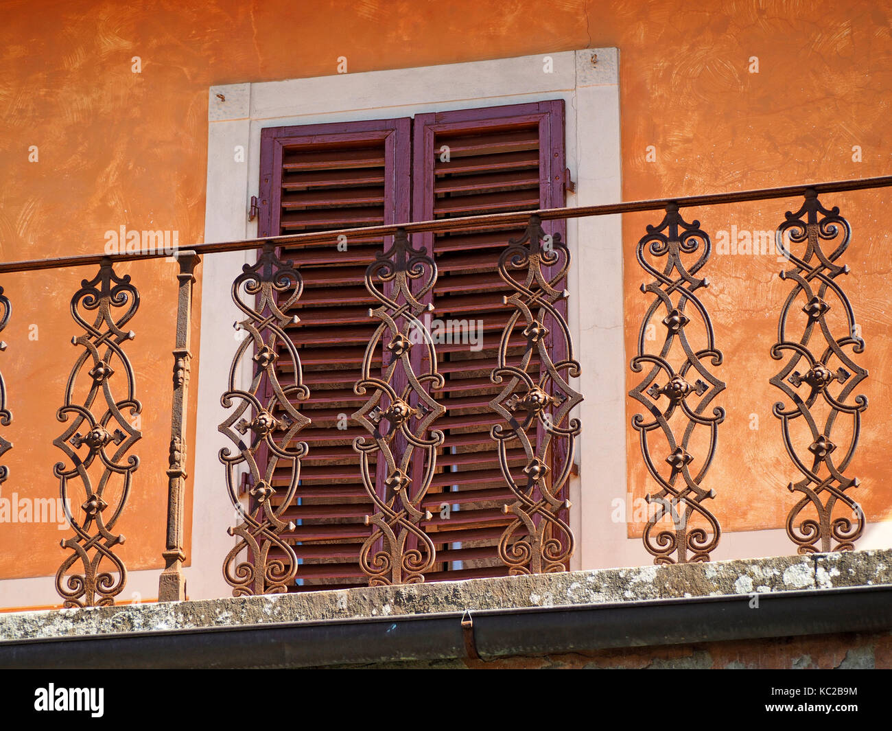 Ornati in lamiera ringhiera sul balcone con finestre con persiane a Fiesole, Firenze in Toscana, Italia Foto Stock