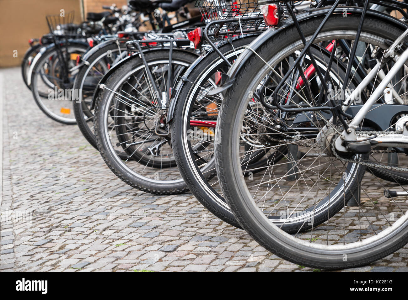 Gruppo di biciclette parcheggiate in una fila in un Parcheggio Foto Stock