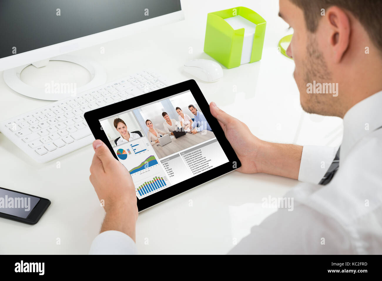 Close-up di imprenditore la videoconferenza con i colleghi sulla tavoletta digitale alla scrivania Foto Stock