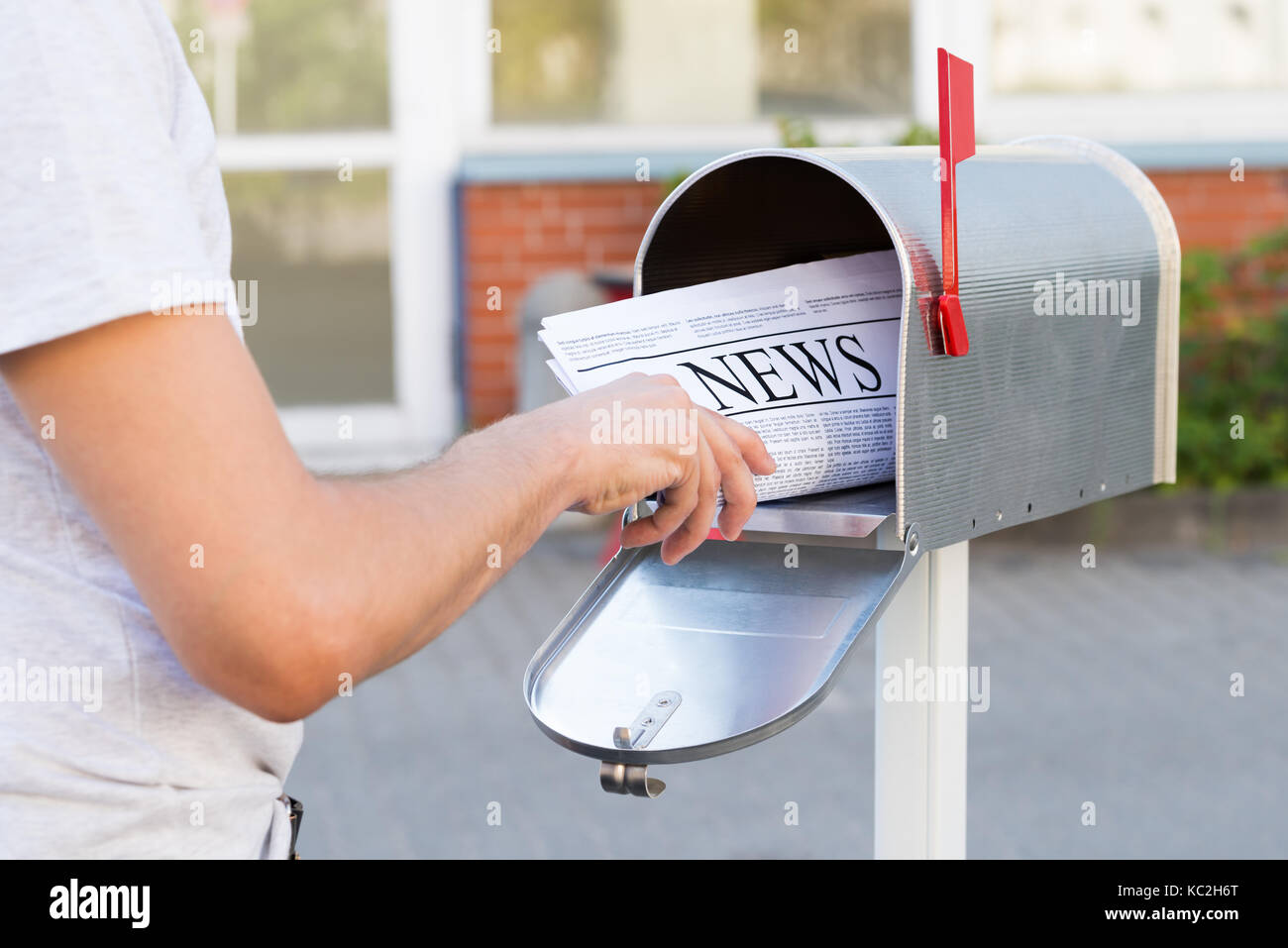 Close-up di persona le mani di aprire la Sua Mailbox per rimuovere il Giornale Foto Stock