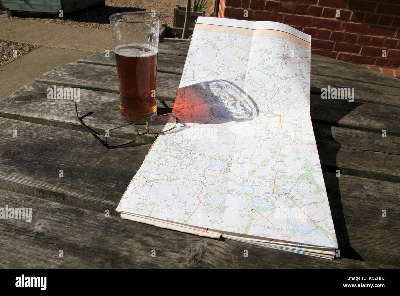 Ordnance Survey Explorer mappa aperto sulla tavola con occhiali e vetro pinta di birra, Suffolk, Inghilterra, Regno Unito Foto Stock