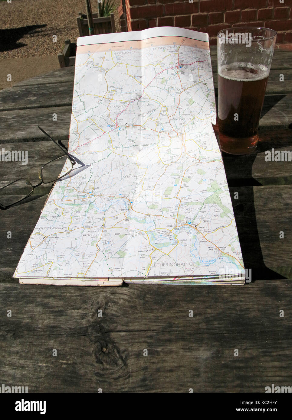 Ordnance Survey Explorer mappa aperto sulla tavola con occhiali e vetro pinta di birra, Suffolk, Inghilterra, Regno Unito Foto Stock