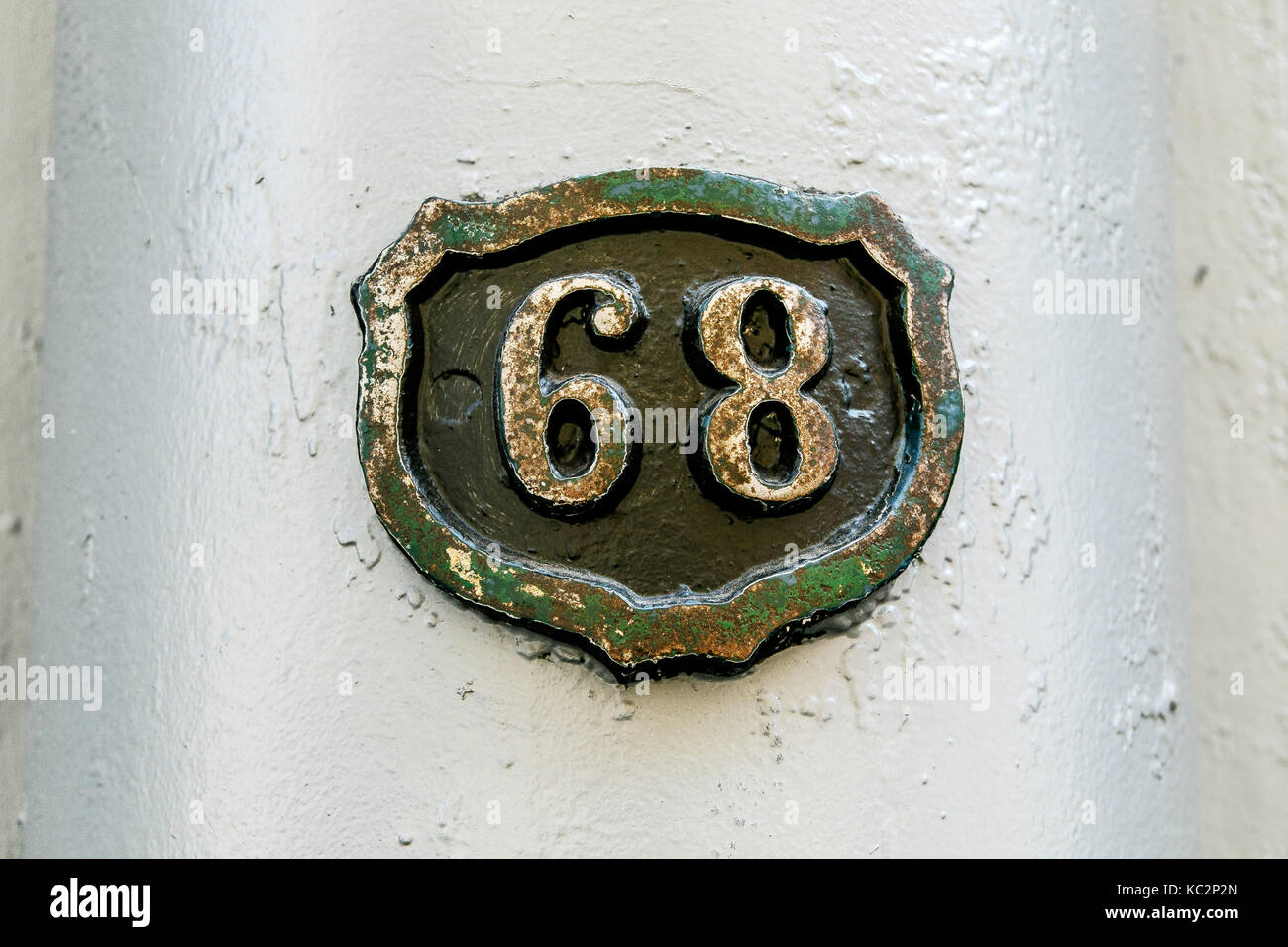 Il numero civico 68 in uno scudo profilo sagomato. Foto Stock