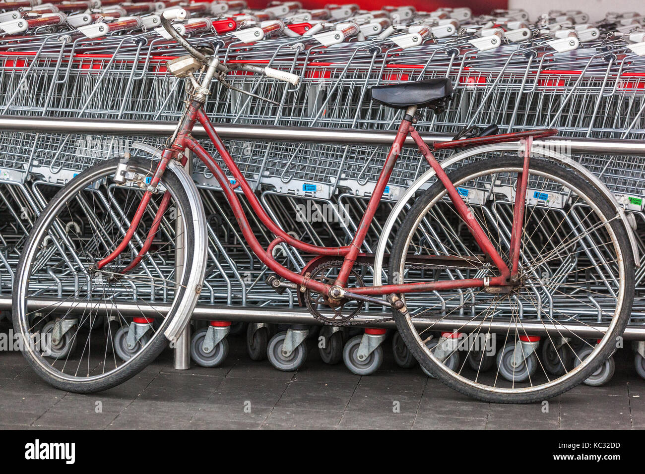 Bicicletta vecchia parcheggiata nei carrelli della spesa biciclette, parcheggiata, all'aperto, negozi, supermercato Foto Stock