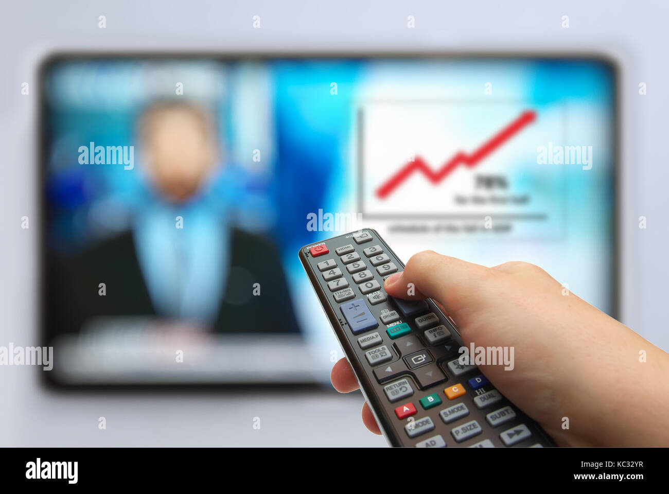 Man mano gli interruttori di canali tv. telecomando in mano e tv. news in prime-time con grafico Foto Stock