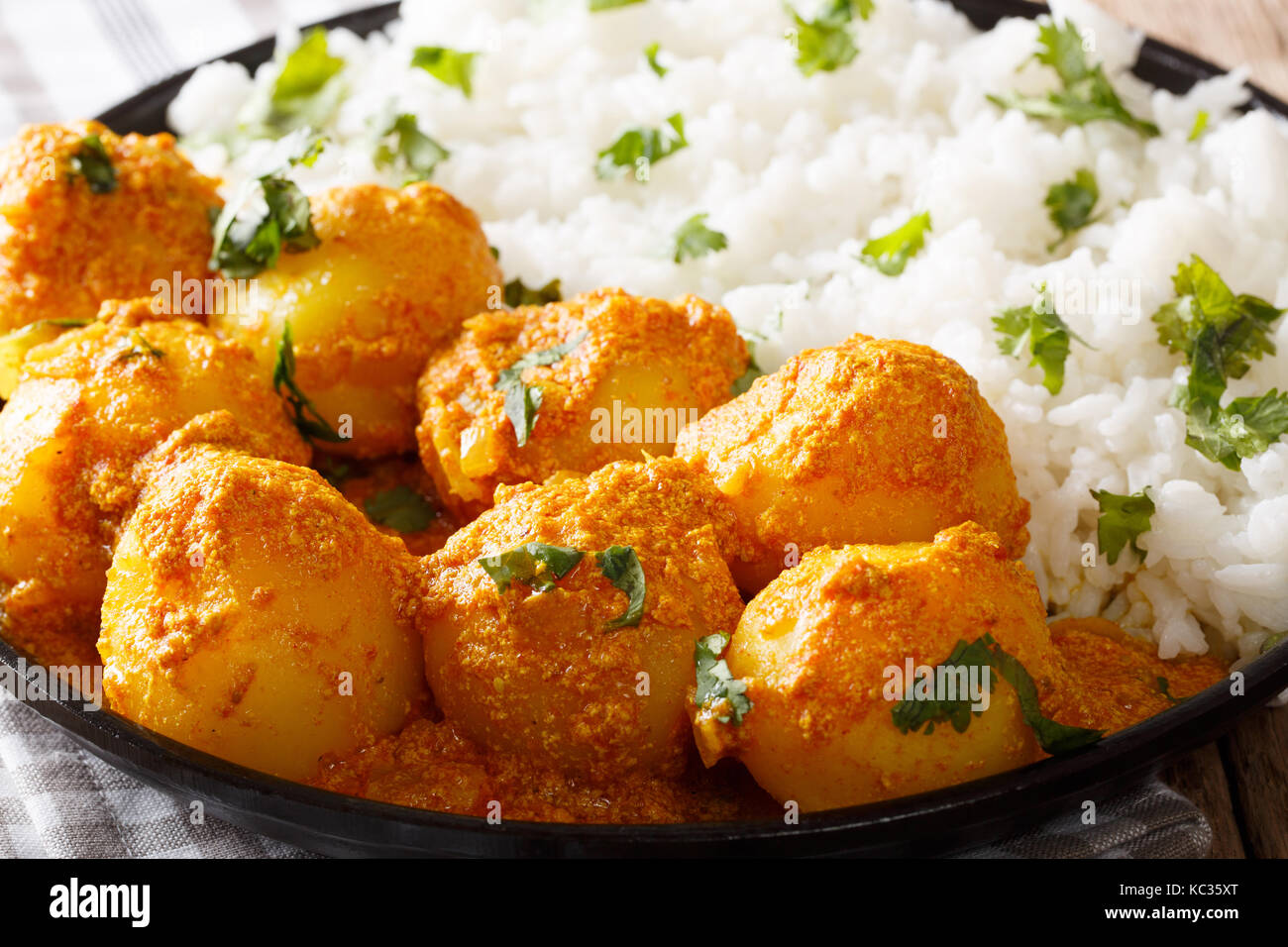 Indian piccante e speziato dum del Kashmir, aloo patate con riso macro sfondo orizzontale Foto Stock