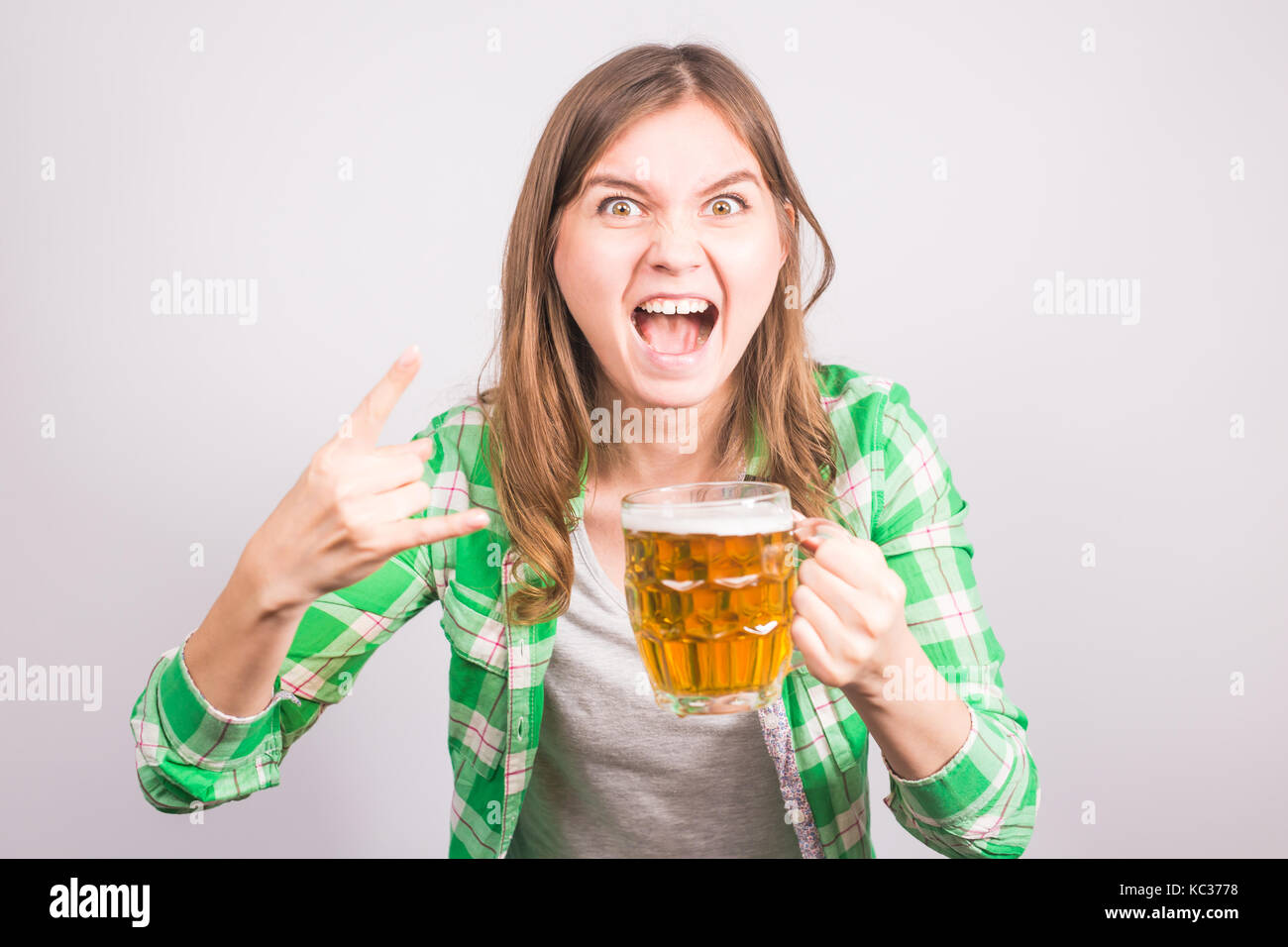 Ritratto di un euforico appassionati di sport in possesso di una bottiglia di birra. La donna con la birra. Foto Stock