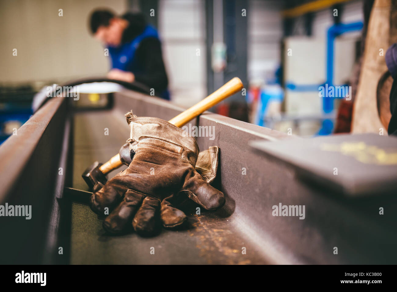 Guanti di protezione e un martello in metallo sullo sfondo del profilo Foto Stock