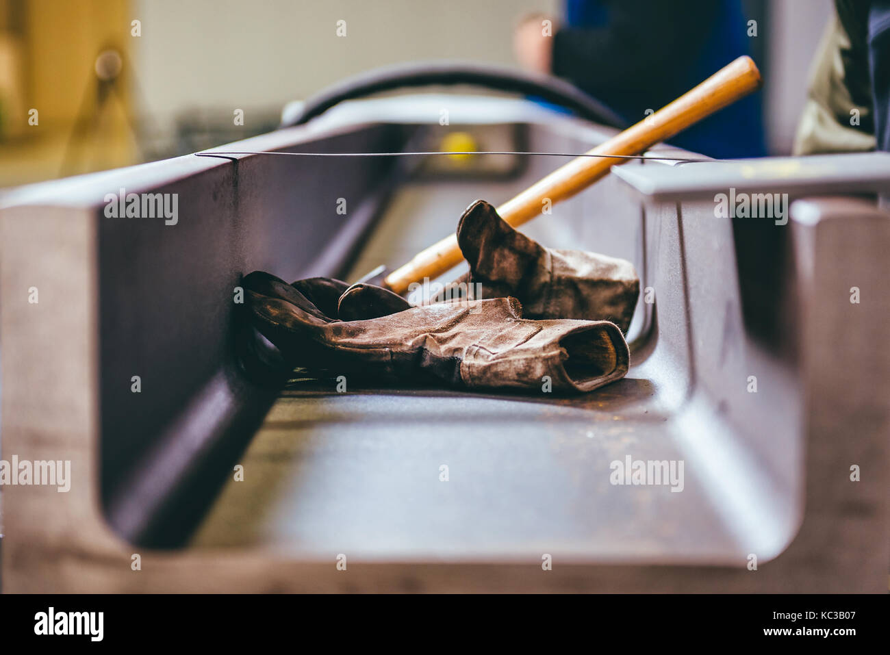 Guanti di protezione e un martello in metallo sullo sfondo del profilo Foto Stock