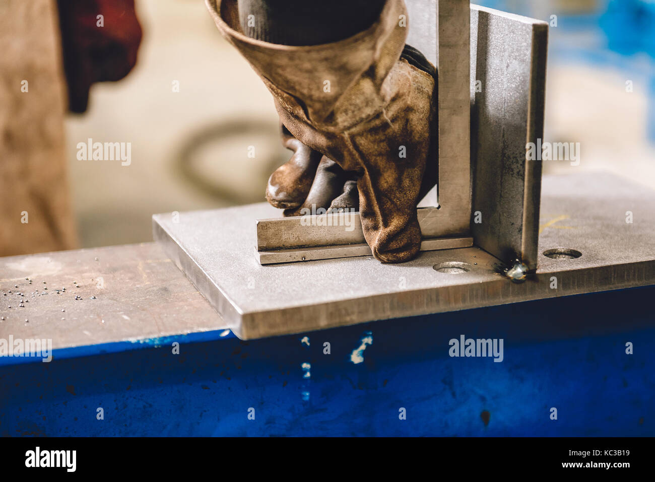 Saldatore controllo angolo di materiali saldati in officina Foto Stock