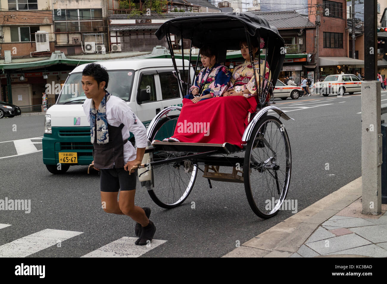 Kyoto, Giappone - 17 maggio 2017: tradizionale potenza umana rickshaw che trasportano donne in kimono Foto Stock