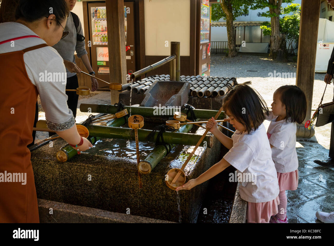Kyoto, Giappone - 18 maggio 2017: bambini pulire le loro mani in un bacino purificaton prima di entrare nel tempio Foto Stock