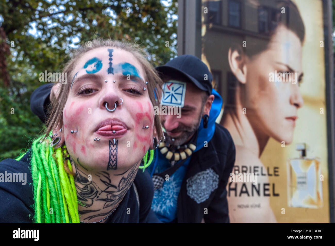 Giovane donna tatuata ragazza con piercing sul viso e tempri verdi, nella parte posteriore è un annuncio sul profumo Chanel, Praga, Repubblica Ceca Foto Stock