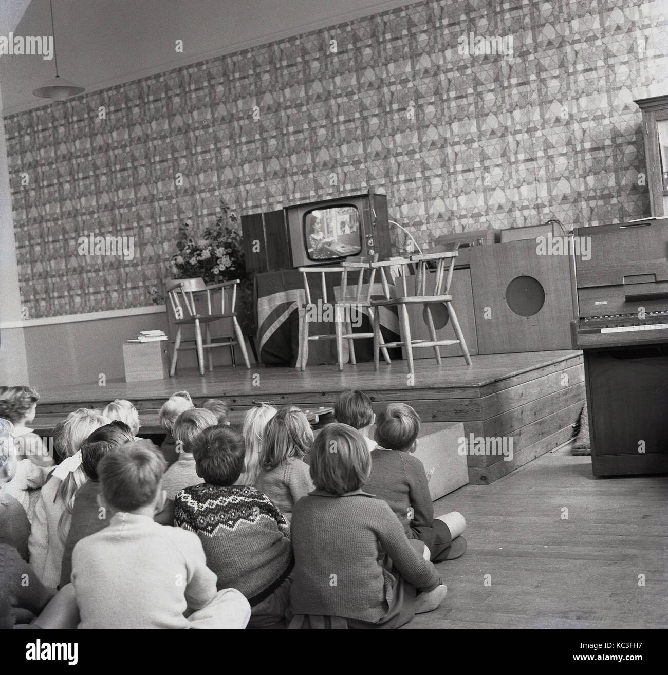 1964, storico gruppo di bambini della scuola primaria si siedono a guardare un programma per bambini su un nuovo televisore. È stato in questo momento che la programmazione per i bambini era prima radiodiffusione nel Regno Unito e le emittenti regalato nuovi televisori per incoraggiare la visualizzazione. Foto Stock