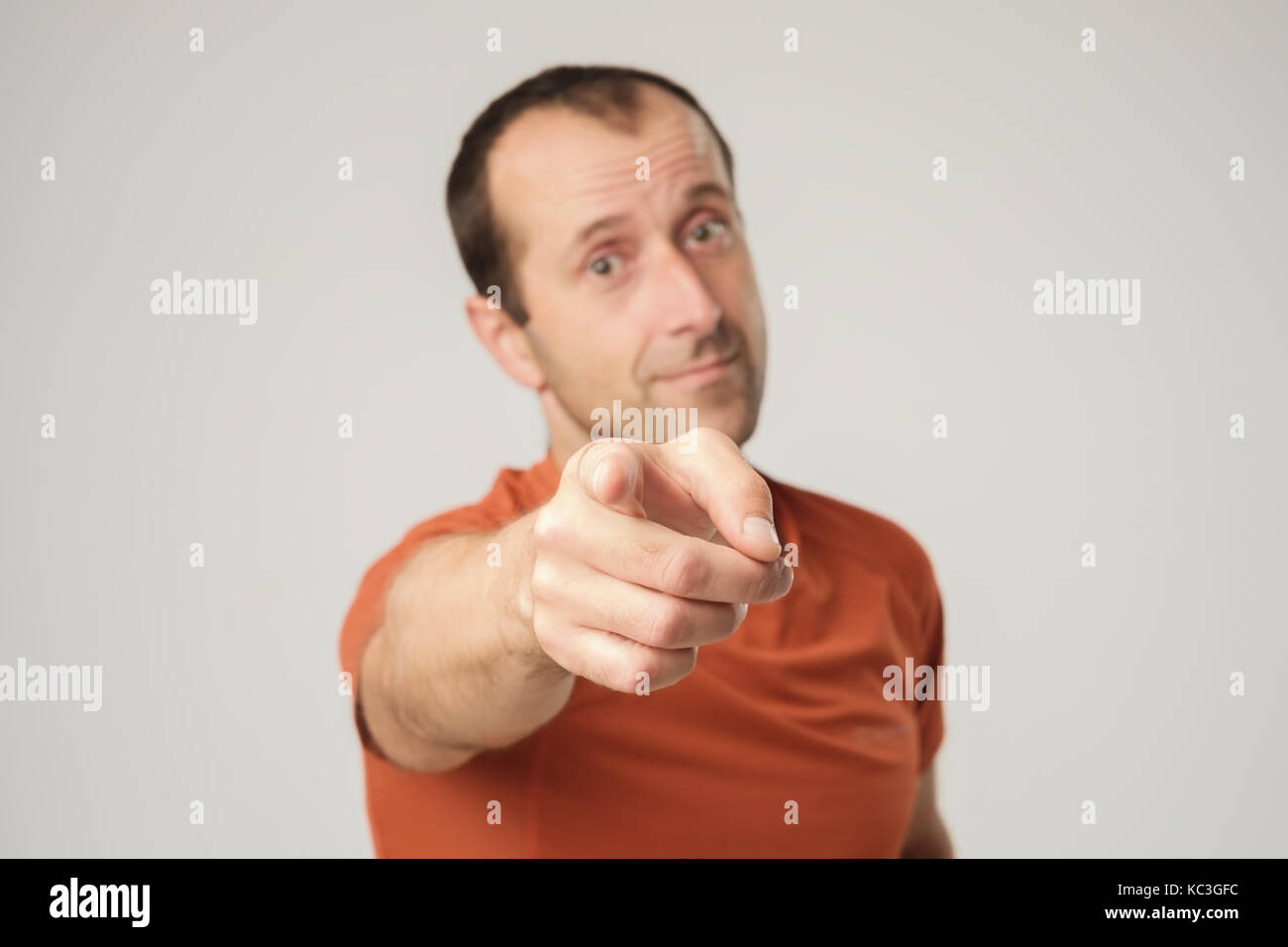Sorridente uomo caucasico in t-shirt puntare il dito a voi. Foto Stock