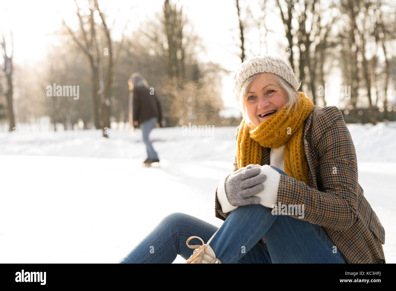 Senior donna con il marito in natura invernale pattinaggio sul ghiaccio. Foto Stock