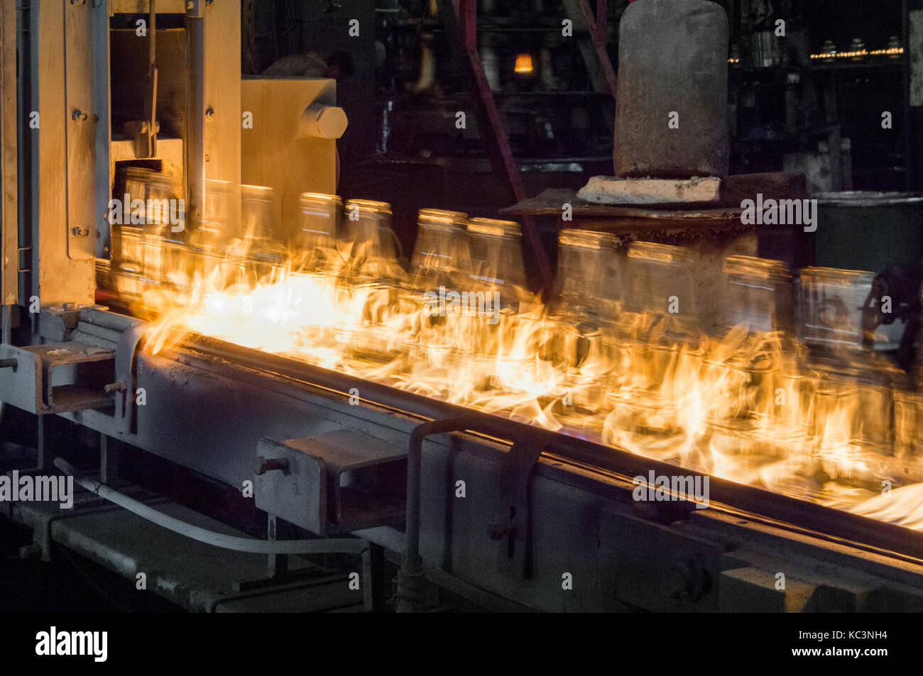 Impianto per la produzione di bottiglie di vetro. bottiglie di vetro su di un nastro trasportatore con il fuoco Foto Stock