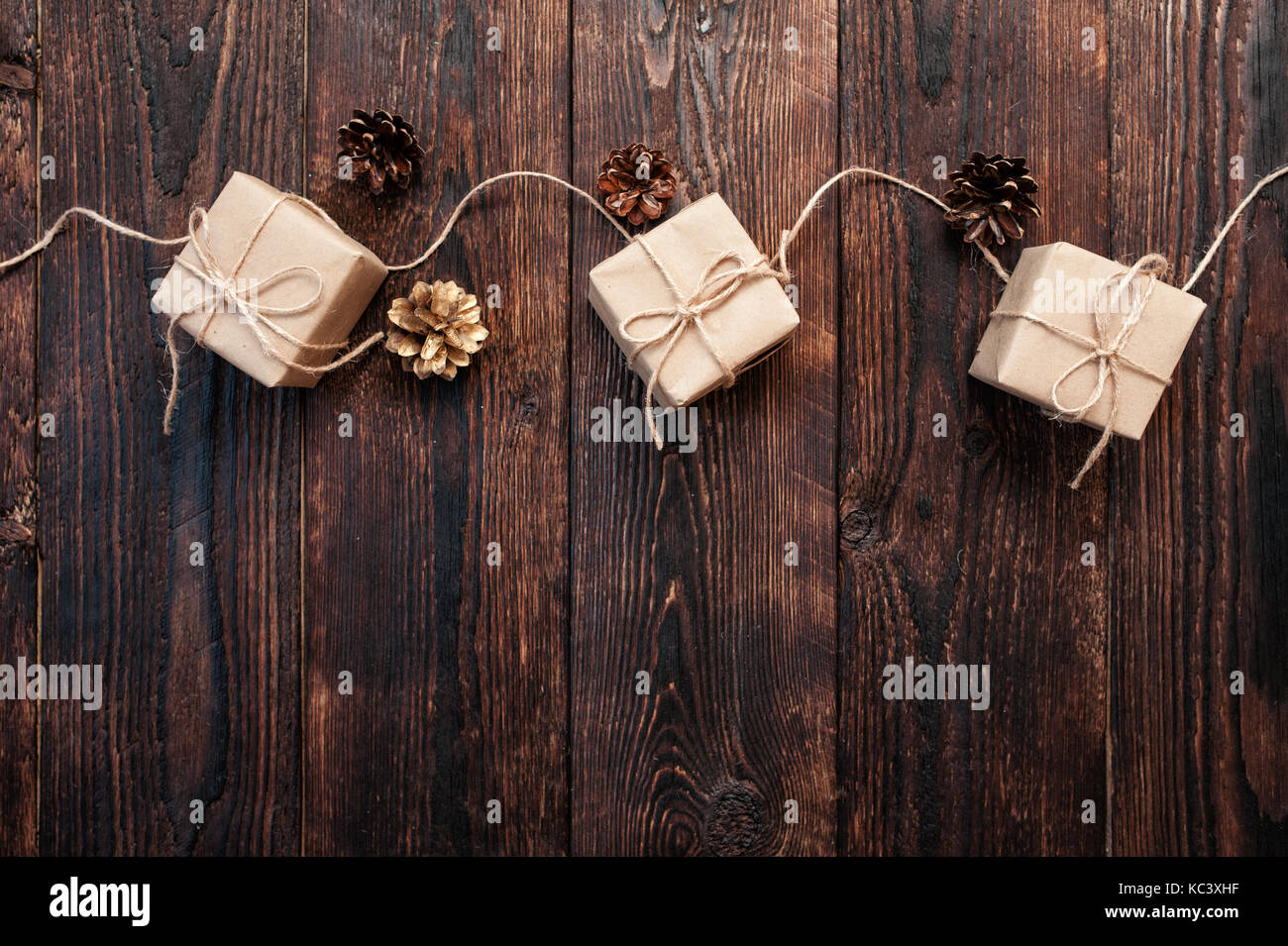 Composizione di Natale da confezioni regalo e coni su uno sfondo di legno Foto Stock
