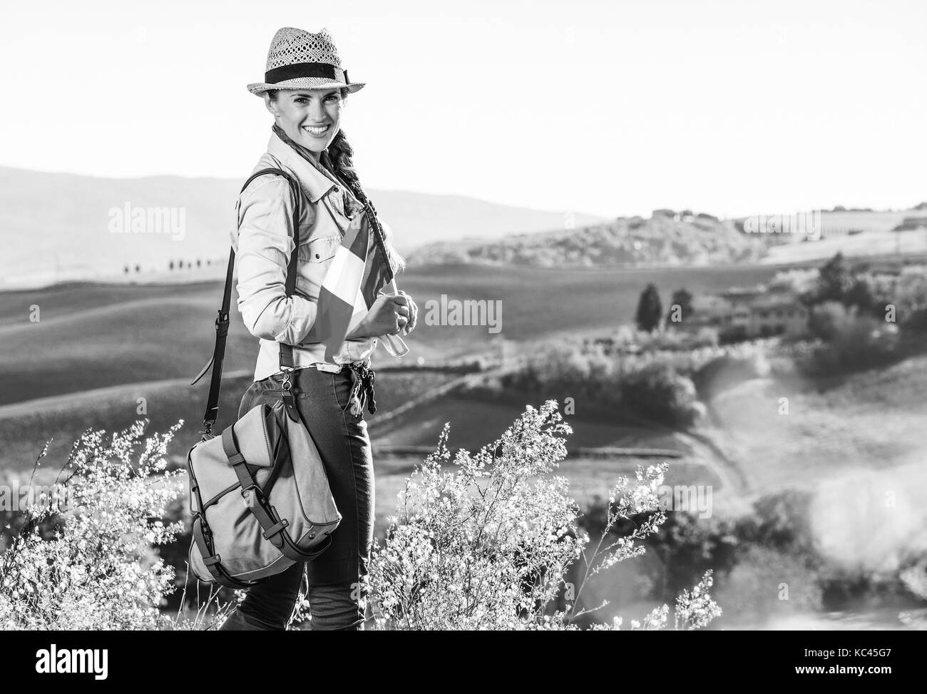 Alla scoperta di magiche vedute della Toscana. ritratto di felice donna attiva escursionista in hat con bandiera italiana escursionismo in toscana Foto Stock