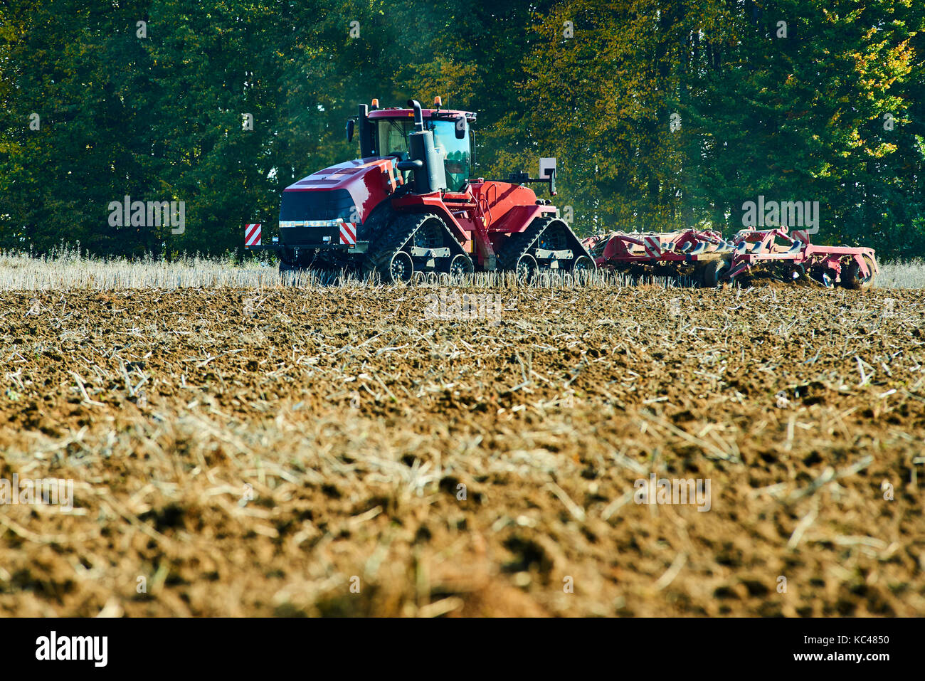 Il lavoro stagionale in un paesaggio agricolo. aratura del trattore sul campo. Foto Stock