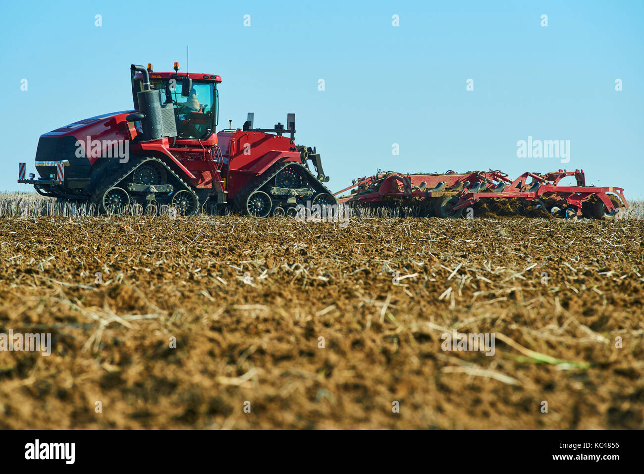 Il lavoro stagionale in un paesaggio agricolo. aratura del trattore sul campo. Foto Stock