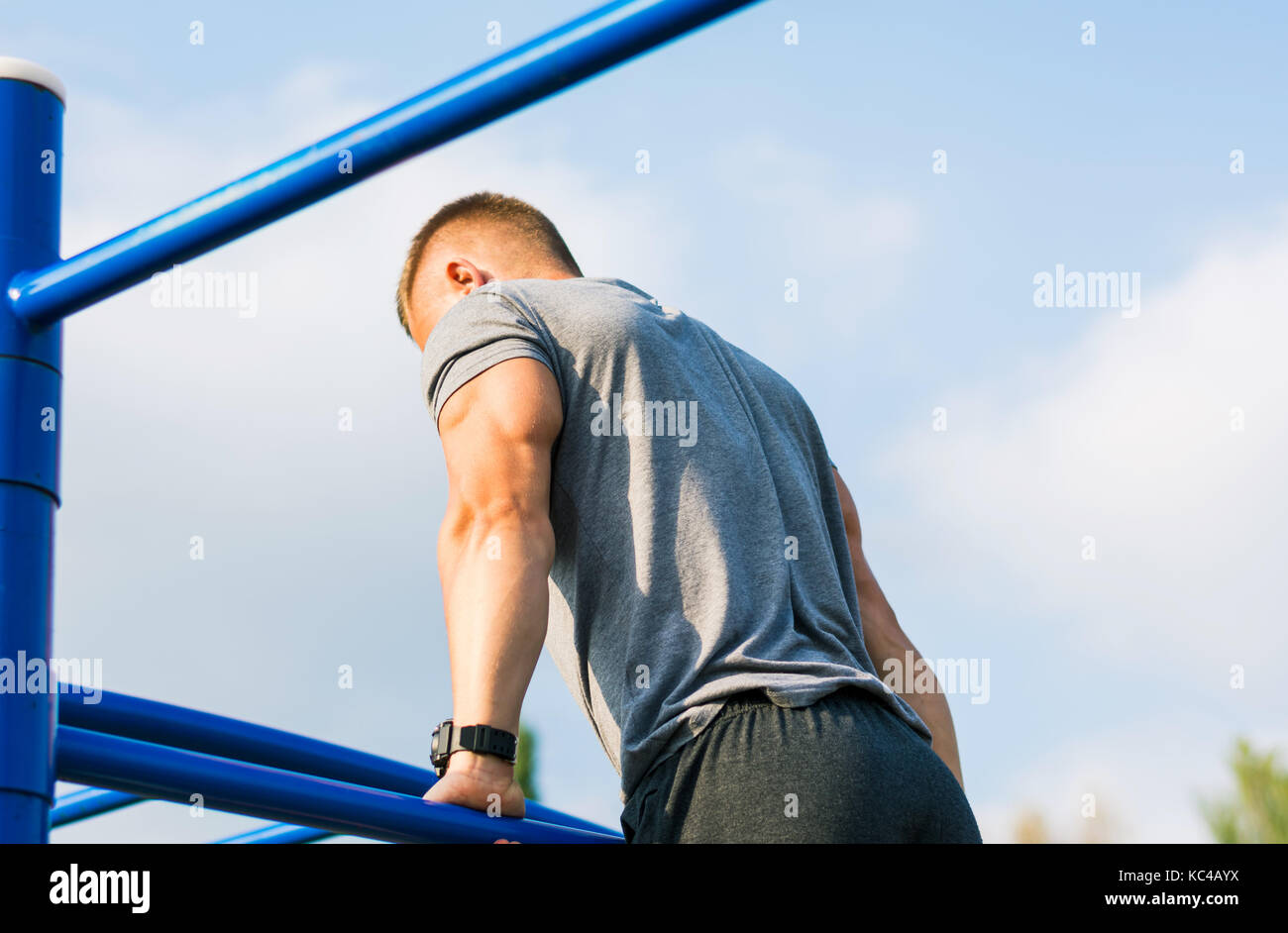 Uomo di eseguire la federazione di pull up su strada allenamento all'aperto Foto Stock