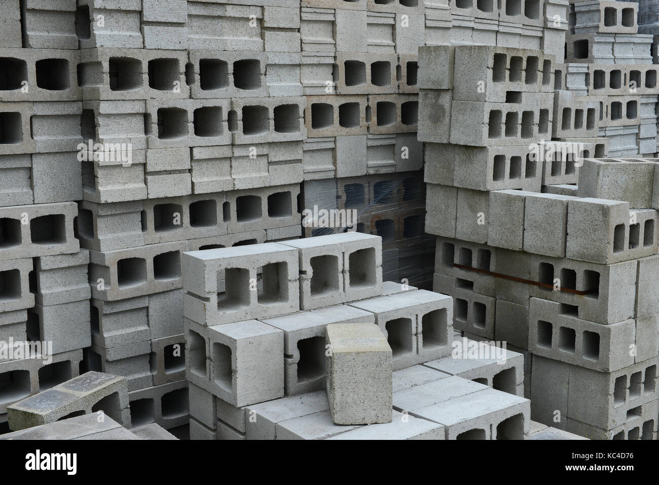 Una pila di un edificio in calcestruzzo blocchi in un cantiere di materiali. Foto Stock